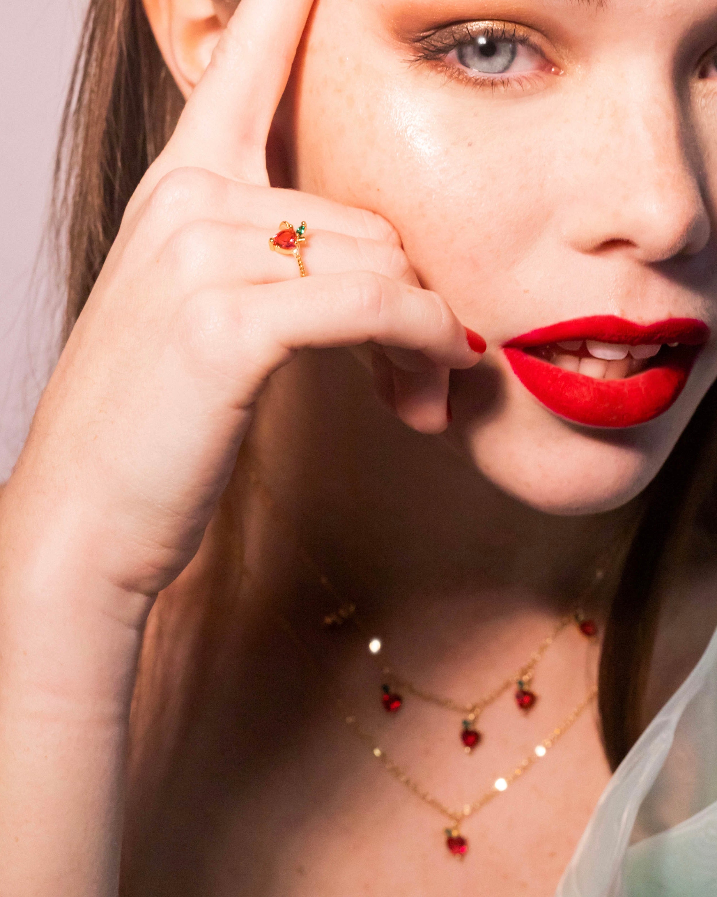 Anello mela placcato in oro 18 carati indossato con rossetto rosso e collana coordinata, Fruits & Jewels