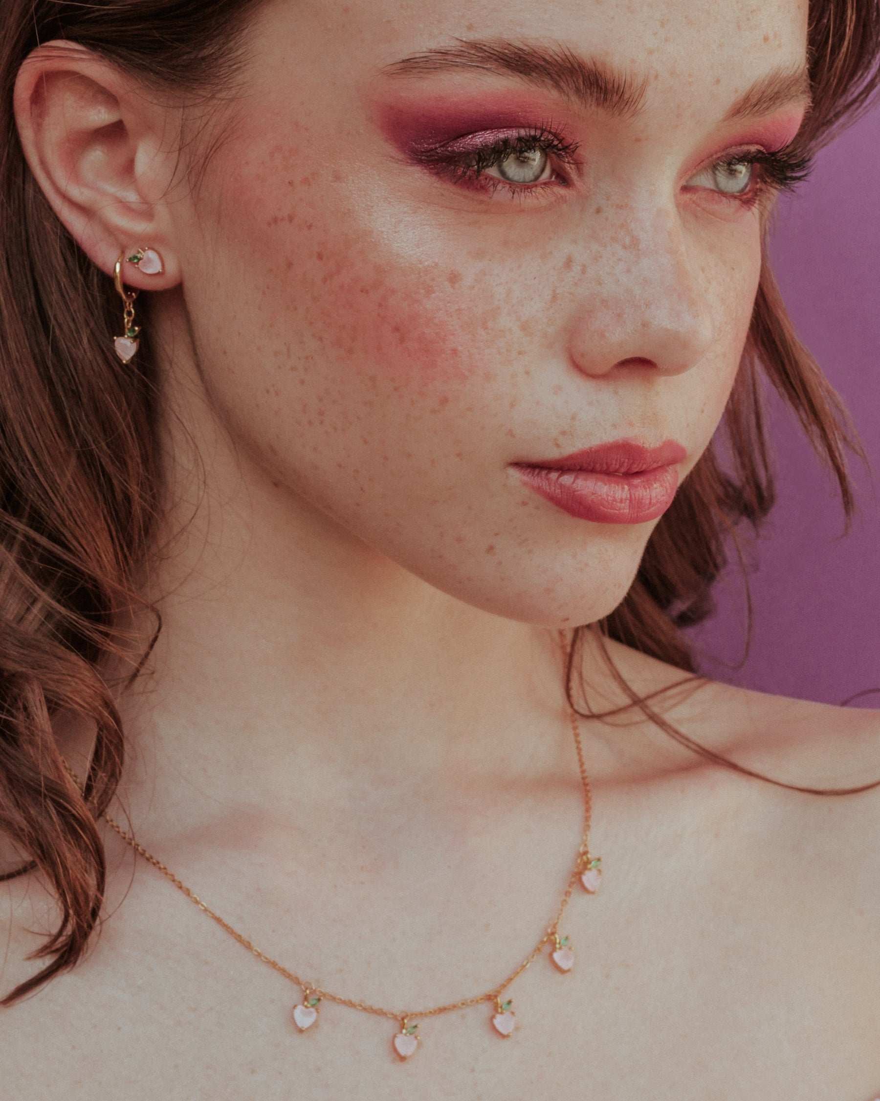Collana charms pesca placcata in oro 18 carati – indossata con look elegante e make-up pesca