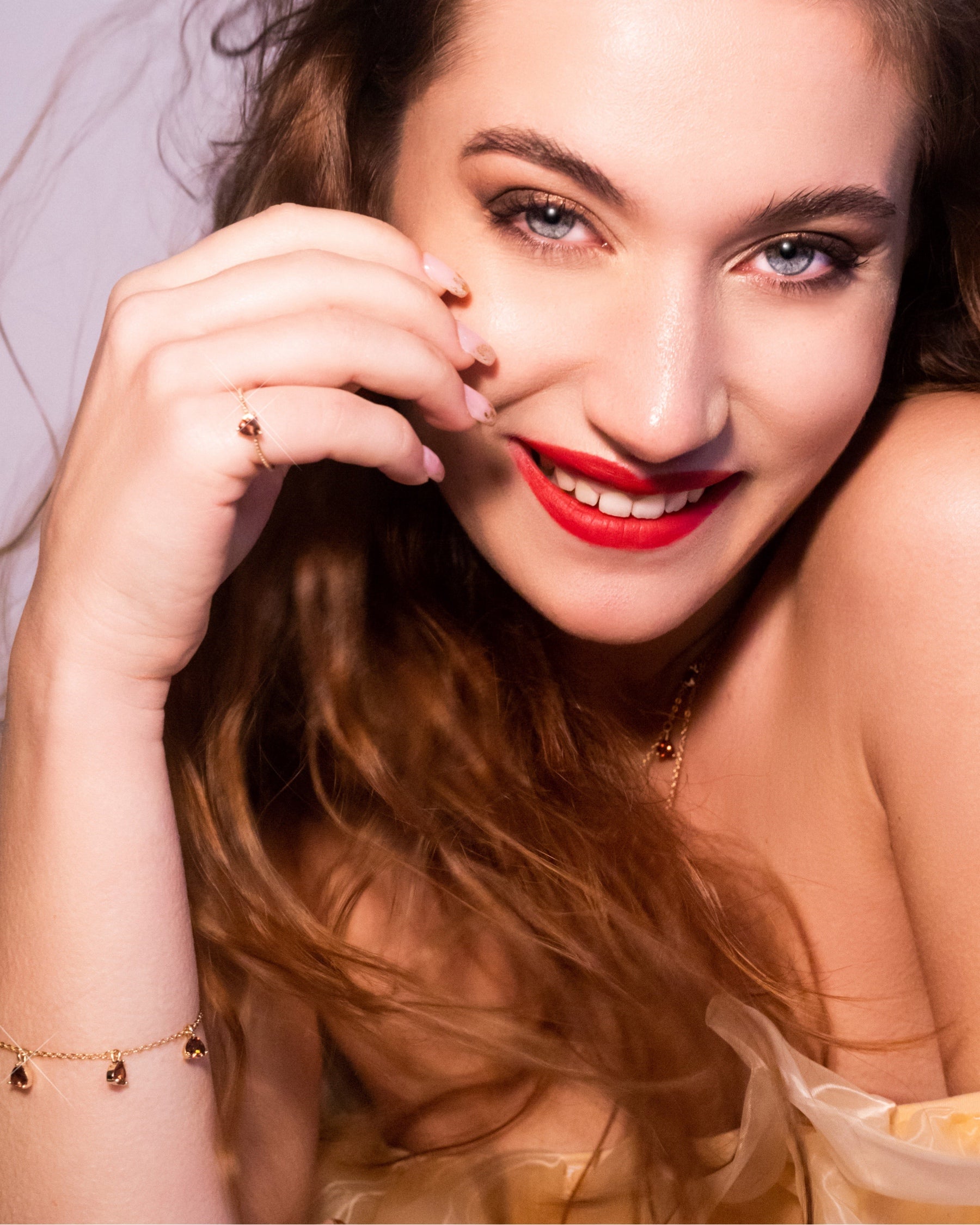 Dettaglio del bracciale castagna placcato in oro 18 carati Fruits & Jewels al polso di una modella sorridente: un tocco caldo, naturale e originale che illumina il look.