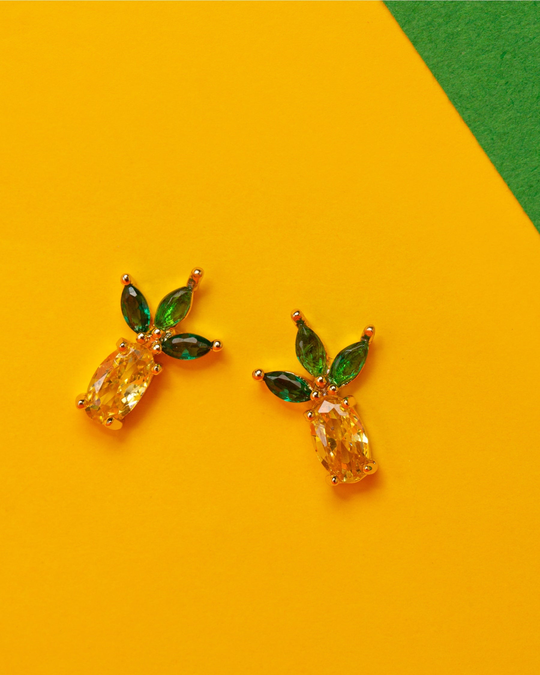 Orecchini a lobo a forma di ananas placcati in oro 18 carati – su sfondo giallo e verde vivace