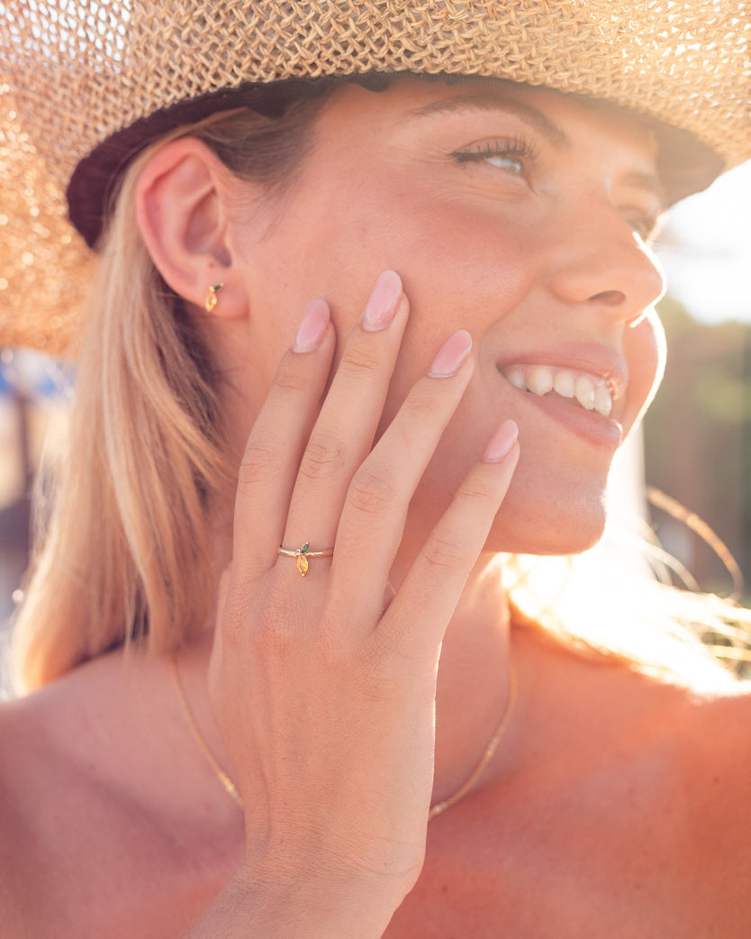 Modella con anello limone dorato posa sorridendo sotto il sole – bijoux fresco e luminoso Fruits & Jewels