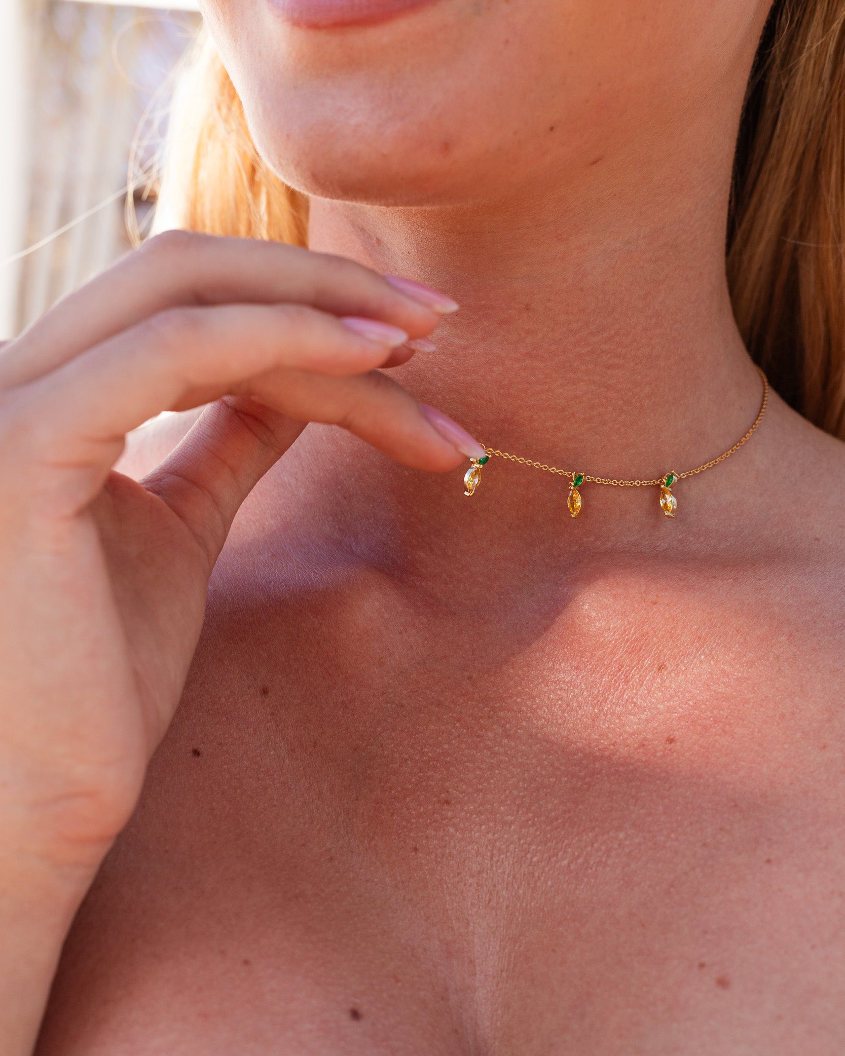 Dettaglio della collana con 5 charms a forma di limone placcati in oro 18 carati indossata da modella – gioielli fruttati Fruits & Jewels