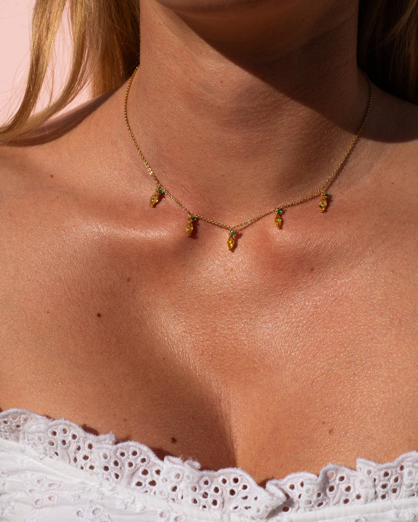 Dettaglio della collana charms limone e bracciale coordinato indossati da modella – set oro estivo by Fruits & Jewels