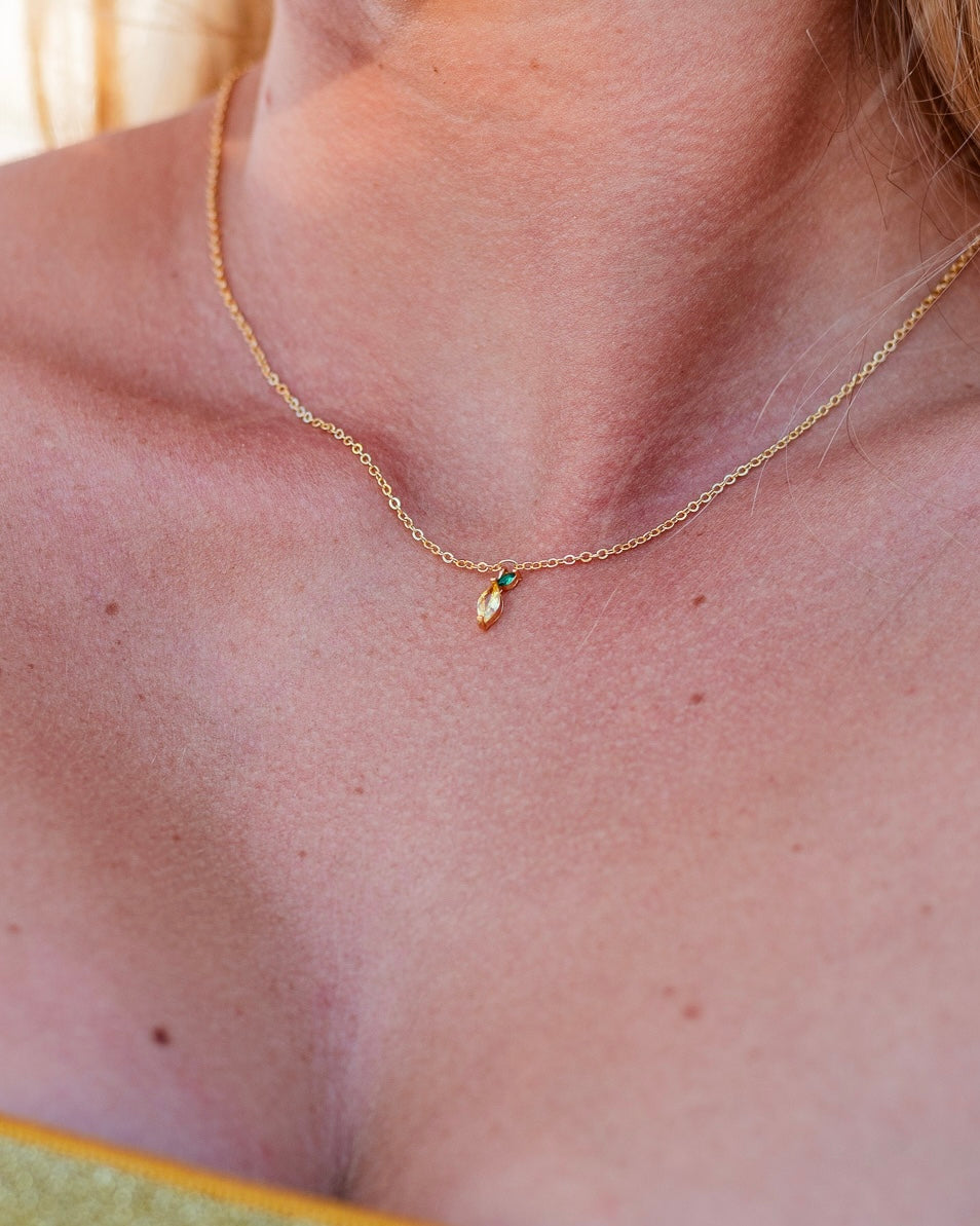 Primo piano sulla collana limone placcata in oro 18 carati, indossata su pelle abbronzata – gioiello estivo minimal di Fruits & Jewels