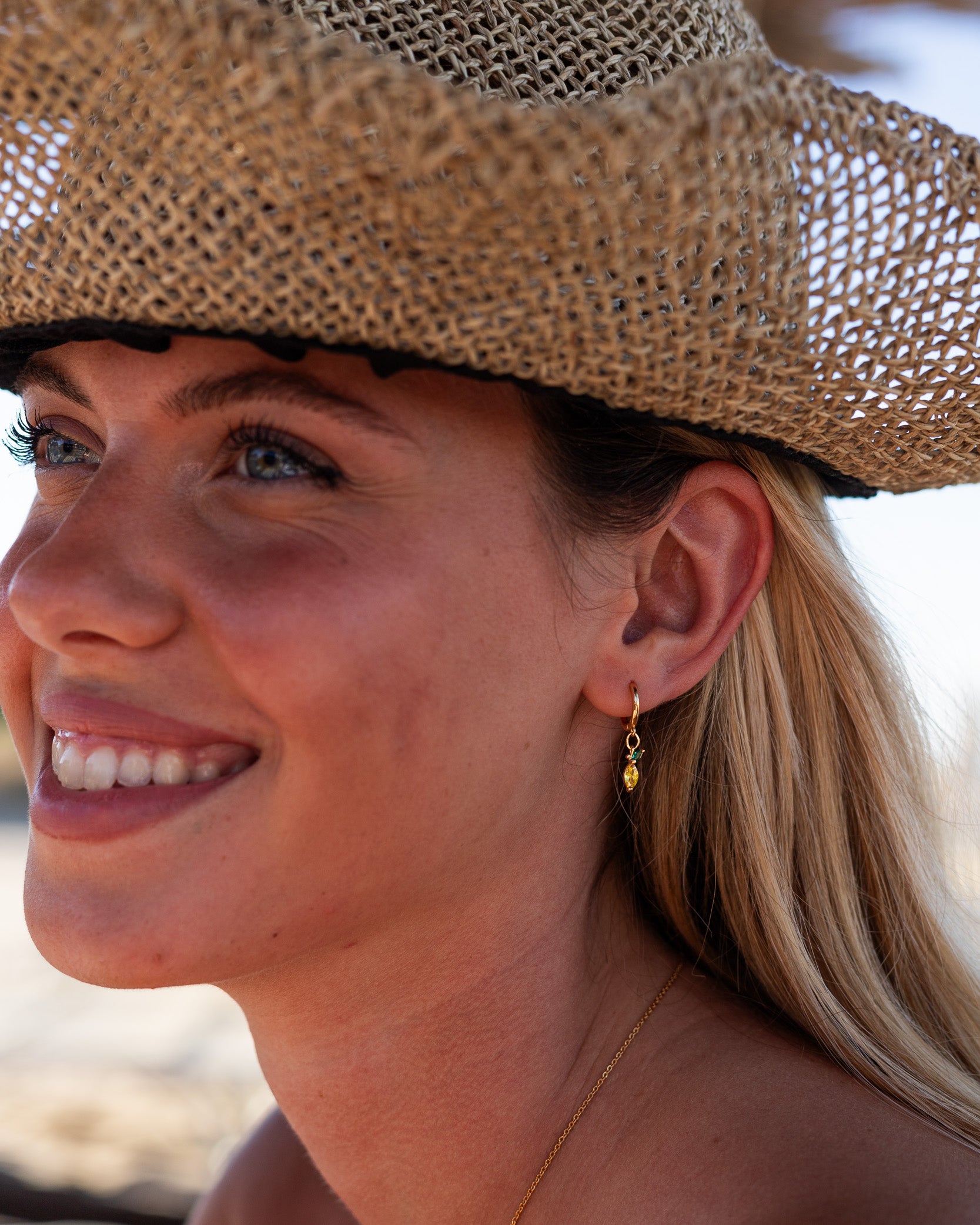 Orecchini limone placcati oro 18 carati indossati da modella al mare – collezione Fruits & Jewels