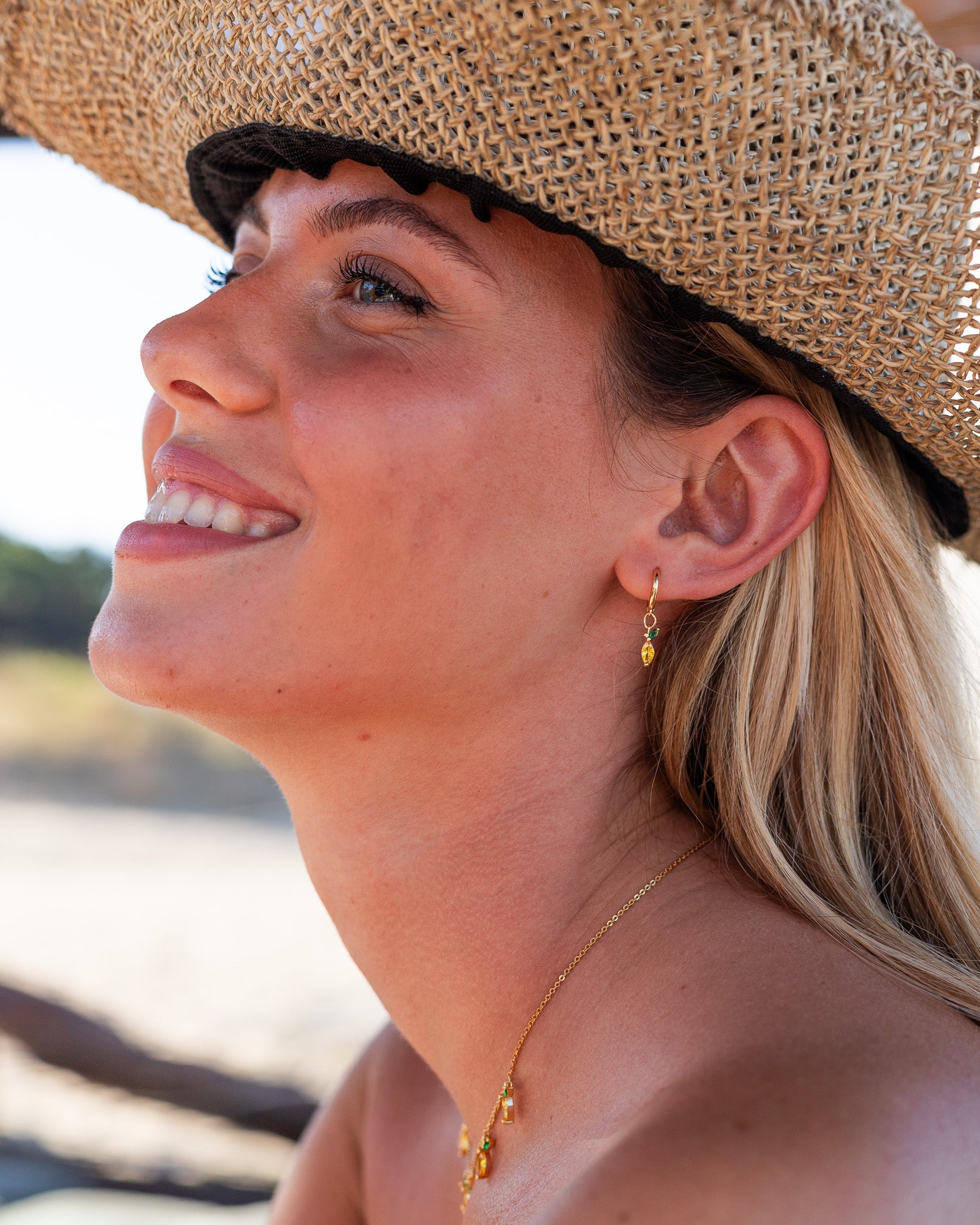 Orecchini e collana limone placcati oro 18 carati indossati da modella al mare – collezione Fruits & Jewels