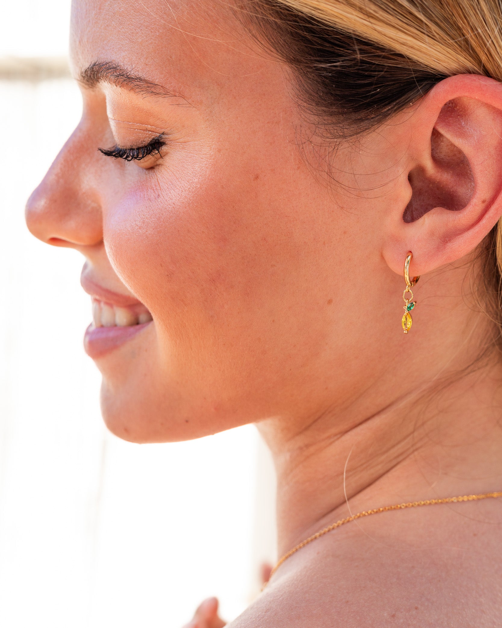 Orecchini limone placcati oro 18 carati indossati da modella al mare – collezione Fruits & Jewels
