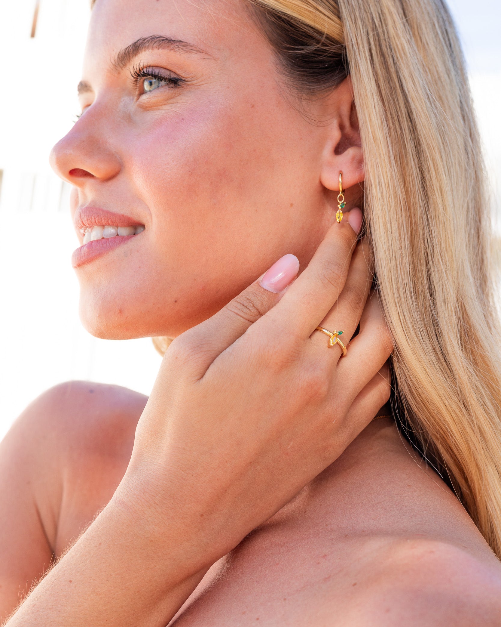 Orecchini e anello limone placcati oro 18 carati indossati da modella al mare – collezione Fruits & Jewels