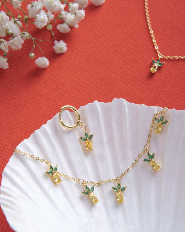 Collana ananas placcata oro – vista flatlay con ciondoli tropicali