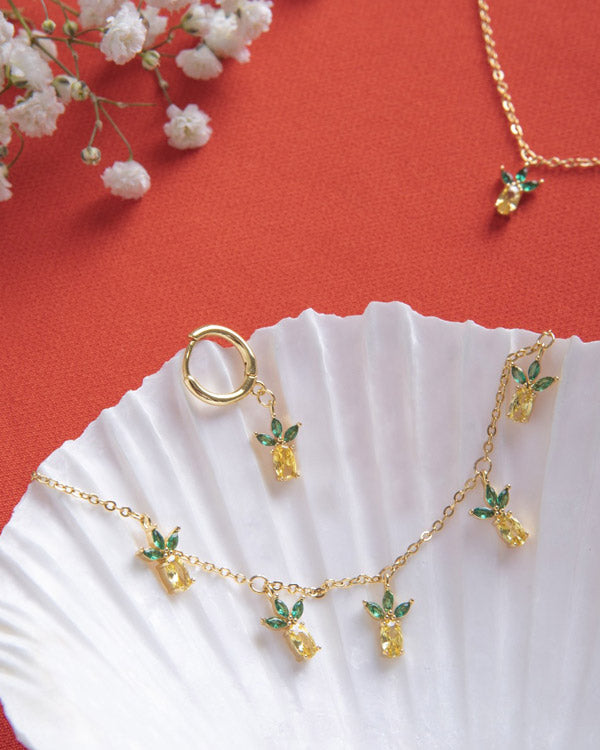 Orecchino e collana ananas – gioielli dorati su conchiglia elegante