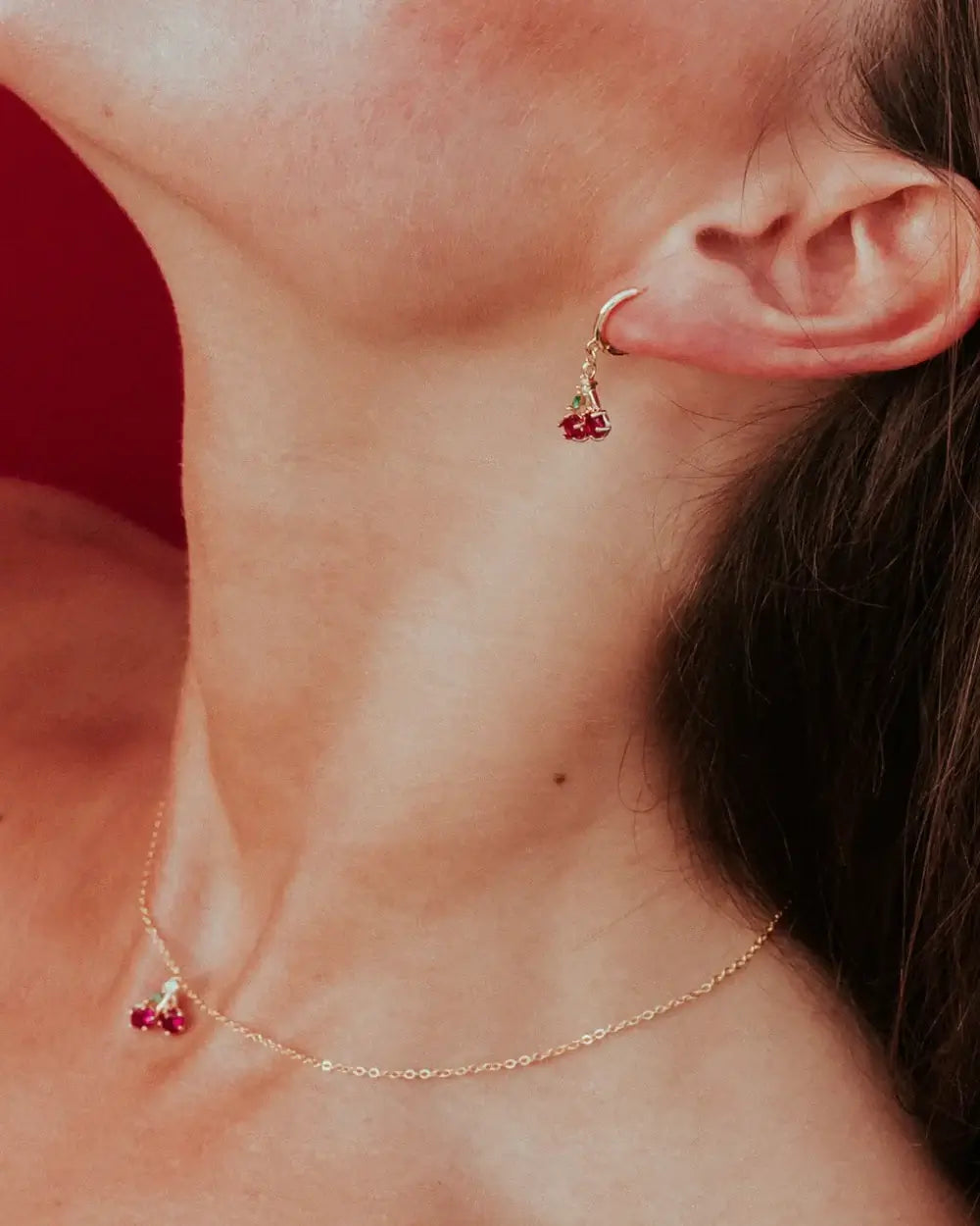 Dettaglio orecchino pendente ciliegia in oro su lobo femminile – gioiello delicato e vitaminico by Fruits & Jewels
