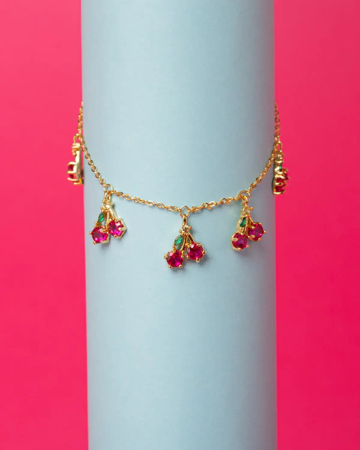Bracciale ciliegia placcato oro su sfondo rosa e azzurro – design fruttato e vivace Fruits & Jewels